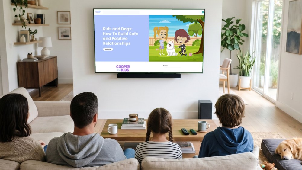A family sitting on a couch watching the Cooper and Kids online program Kids and Dogs: How To Build Safe and Positive Relationships on a large living room TV.
